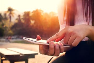 Close up of a woman using mobile smartphone in sunset Close up of a woman using mobile smartphone in sunset image small