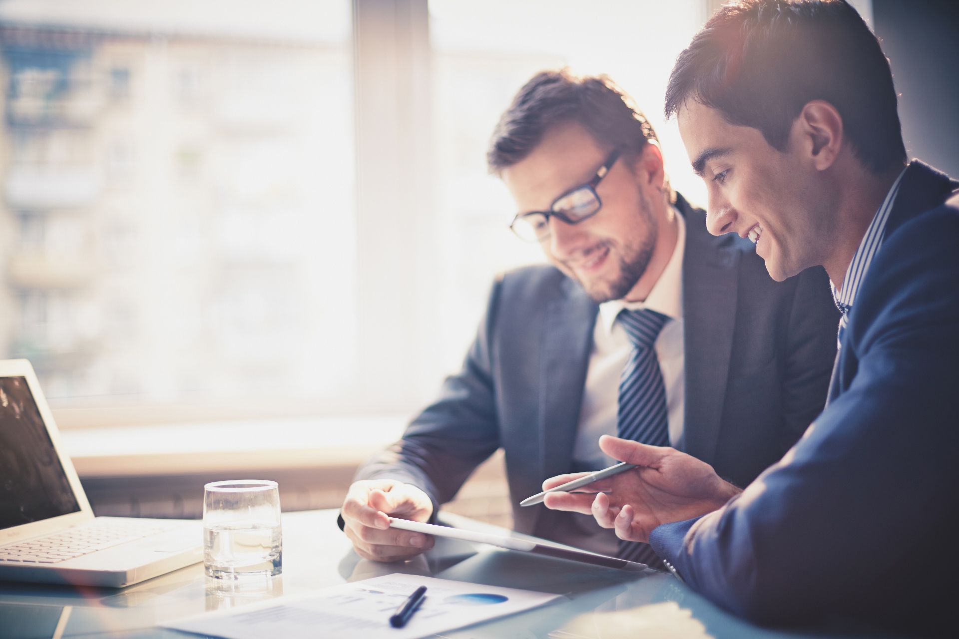 Two businessmen using touchpad at meeting Two businessmen using touchpad at meeting background image